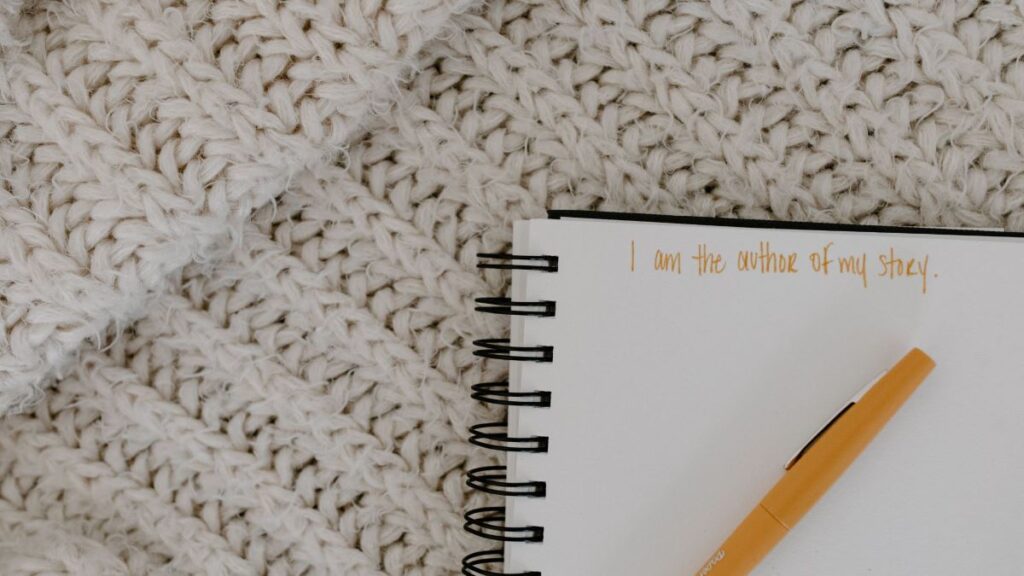 journal with pen on top of a blanket