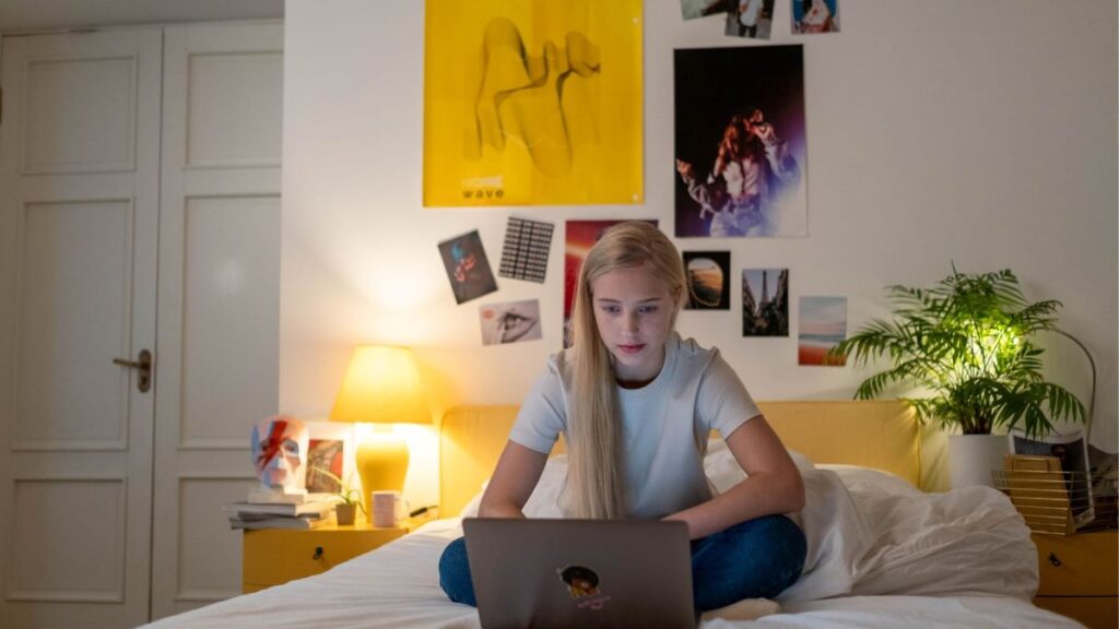 teen on a computer in a bedroom