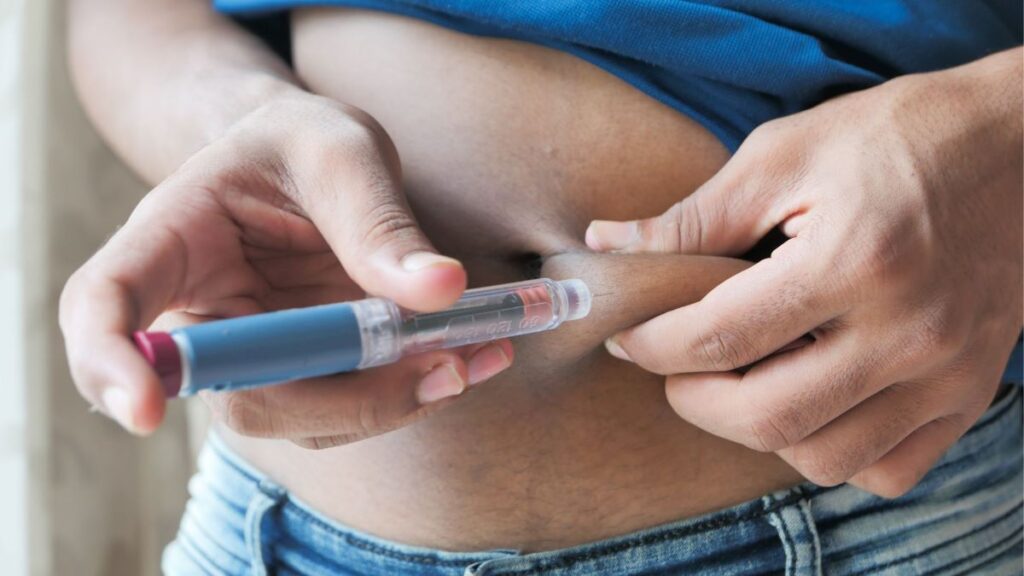 individual injecting insulin into addomen