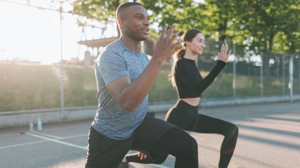 man and women lunging outside