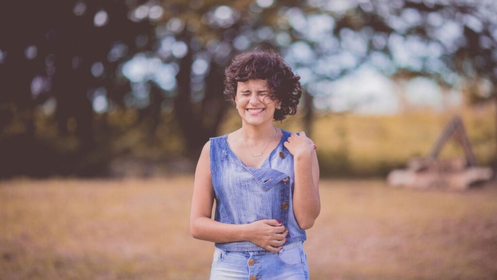 girl standing in a field closing her eyes